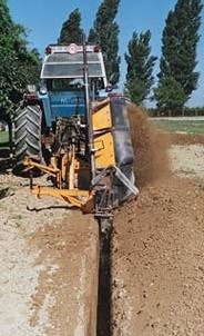 Dondi DRENAG cutting a trench behind a tractor